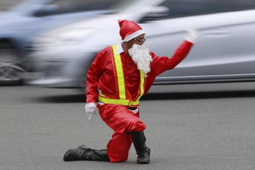 Traffic enforcer Ramiro Hinojas wears a Santa Claus costume while directing traffic flow at a busy intersection in Pasay city, metro Manila, December 12, 2015. Hinojas busts some dance moves while directing traffic to entertain motorists stuck in the congested intersection as holiday-goers crowd malls for their yuletide shopping a few days before Christmas. REUTERS/Romeo Ranoco