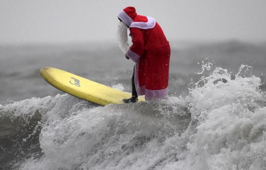A member of the Langland Board Surfers group takes part in a Surfing Santa competition at Langland Bay in Gower, Wales, December 19, 2015. REUTERS/Rebecca Naden